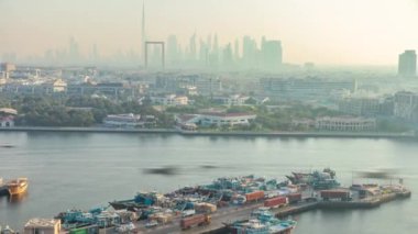 Dubai creek manzara timelapse tekneler ve gemi limanda ve gün batımı sırasında arka planda modern binalar