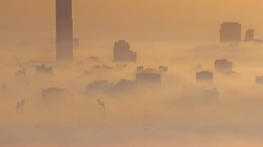 Dubai şehrinin gökdelenleri Deira 'da sabah sisi ile kaplıydı ve festival şehri havacılık zaman çizelgesi yukarıdan gündoğumunda Birleşik Arap Emirlikleri