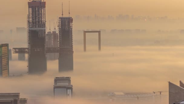 Vista aérea de arranha-céus em construção cobertos por nevoeiro no Dubai timelapse. — Vídeo de Stock