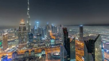 Dubai 'deki en yüksek kulelerin havadan görünüşü şehir merkezinin ufuk çizgisi ve karayolu gece zaman çizelgesi.