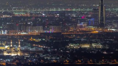 Zabeel bölgesinde arka planda gökdelenleri olan bir bahçe. Dubai, BAE 'de hava gece zaman çizelgesi.