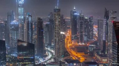 Şehir merkezinin ufuk çizgisi, modern mimari biçimle gece zamanının üstünde. Dubai iş hangarı kulelerinin hava görüntüsü.