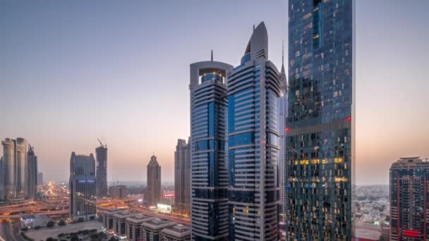 Vista aérea del Distrito Financiero Internacional de Dubái con muchos rascacielos día a noche timelapse. — Vídeos de Stock