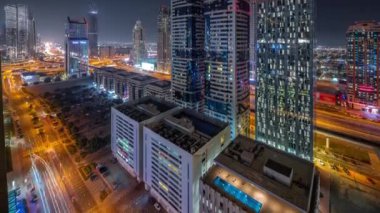Dubai Uluslararası Finans Bölgesi 'nin birçok gökdelen gece zaman çizelgesiyle hava görüntüsü.