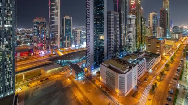 Vista aérea del Distrito Financiero Internacional de Dubái con muchos rascacielos nocturnos timelapse. — Vídeo de stock