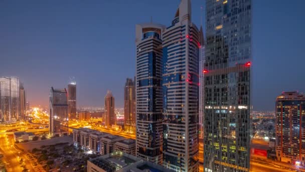 Vista aérea del Distrito Financiero Internacional de Dubái con muchos rascacielos noche a día timelapse. — Vídeos de Stock