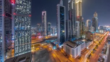 Dubai Uluslararası Finans Bölgesi 'nin birçok gökdelen gece zaman çizelgesiyle hava görüntüsü.