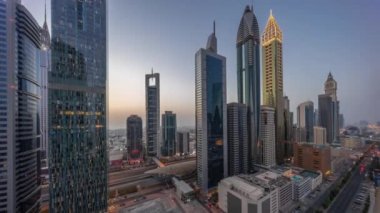 Dubai Uluslararası Finans Bölgesi 'nin hava görüntüsü. Günbegün ve gece birçok gökdelen var..
