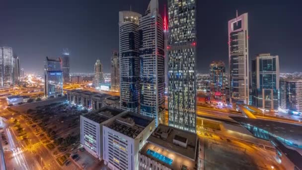 Vista aérea del Distrito Financiero Internacional de Dubái con muchos rascacielos nocturnos timelapse. — Vídeos de Stock