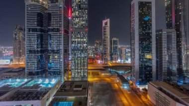 Dubai Uluslararası Finans Bölgesi 'nin birçok gökdelen gece zaman çizelgesiyle hava görüntüsü.