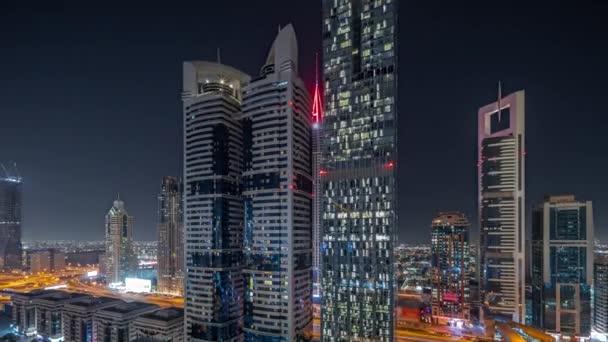 Panorama que muestra la vista aérea del Distrito Financiero Internacional de Dubai con muchos rascacielos nocturnos timelapse. — Vídeos de Stock