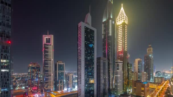Flygfoto över Dubai International Financial District med många skyskrapor hela natten timelapse. — Stockvideo