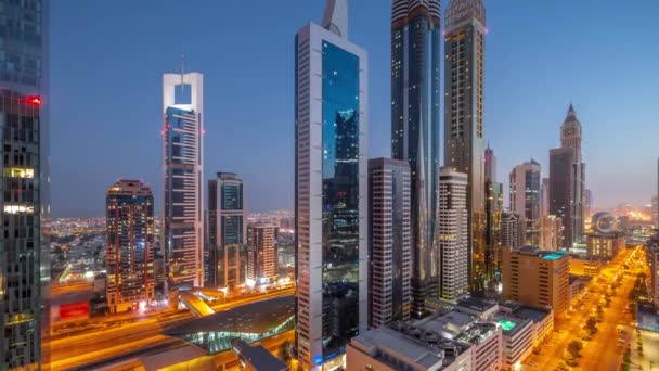 Luftaufnahme des Dubai International Financial District mit vielen Wolkenkratzern im Zeitraffer von Nacht zu Tag. — Stockvideo