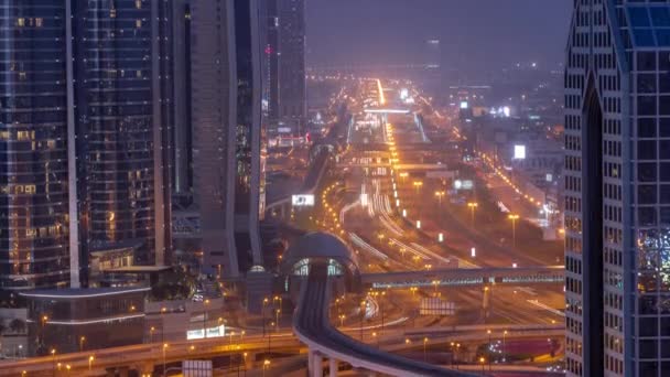 Ocupado Sheikh Zayed carretera aérea noche al día timelapse, metro ferrocarril y rascacielos modernos alrededor en la ciudad de lujo de Dubai. — Vídeo de stock