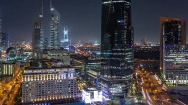Dubai Uluslararası Finans Bölgesi 'nin birçok gökdelen gece zaman çizelgesiyle hava görüntüsü.