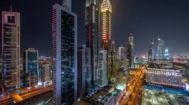 Dubai Uluslararası Finans Bölgesi 'nin birçok gökdelen gece zaman çizelgesiyle hava görüntüsü.