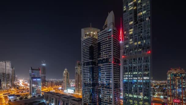 Vista aérea del Distrito Financiero Internacional de Dubai con muchos rascacielos durante toda la noche timelapse. — Vídeos de Stock