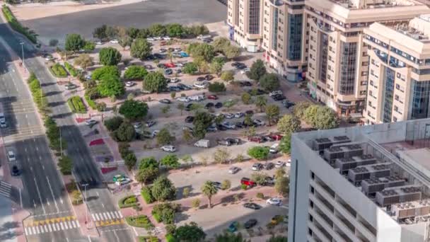 Rijen van auto 's geparkeerd op een parkeerplaats tussen lijnen van groene lommerrijke bomen gezien vanaf boven de hele dag timelapse — Stockvideo