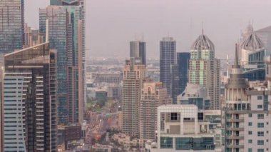 Dubai Marina ve Medya Şehri 'nin modern gökdelenleri ve ofis binaları ile gündüz ve gece saatleri.