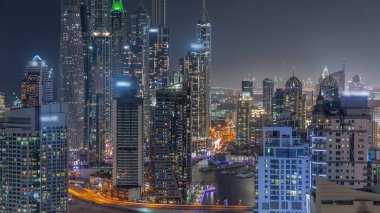 Dubai Marina 'nın en yüksek karşılama bloğundaki çeşitli gökdelenlerin görüntüsü suni kanallı gece zaman ayarlı. Limanda çok sayıda kule ve yat var.