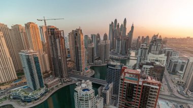 Sunrise Airial Timelapse sırasında Dubai Marina 'nın en yüksek karşılama bloğundaki çeşitli gökdelenlerin suni kanallı panoraması. Sabahın erken saatlerinde pek çok kule ve yat