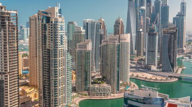 Dubai Marina 'nın en yüksek karşılama bloğundaki çeşitli gökdelenlerin görüntüsü suni kanallı zaman ayarlı. JBR ve yatlarda birçok kule var.