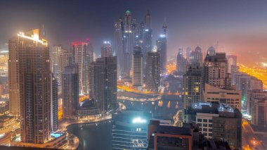 Dubai Marina hava sahasının en yüksek bloğundaki çeşitli gökdelenlerin görüntüsü. Gece gündüz yapay kanalla geçiş zamanı. Güneş doğmadan önce birçok kule ve yat sisli.