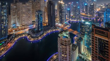Dubai Marina hava sahasının en uzun bloğundaki çeşitli gökdelenlerin görüntüsü suni kanallı gece zaman ayarlı. Pencereleri ve yatları yanıp sönen bir sürü kule var.