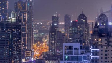 Dubai Marina ve Medya Şehri semtleri modern gökdelenleri ve ofis binaları ile tüm gece boyunca antenli.