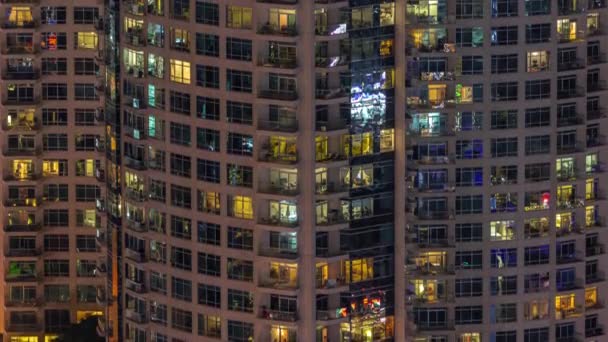 Вечірній вид на зовнішню квартиру житловий будинок часовий проміжок з сяючими вікнами — стокове відео