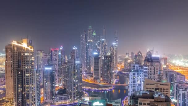 Uitzicht op verschillende wolkenkrabbers in hoogste recidentiële blok in Dubai Marina antenne de hele nacht timelapse — Stockvideo