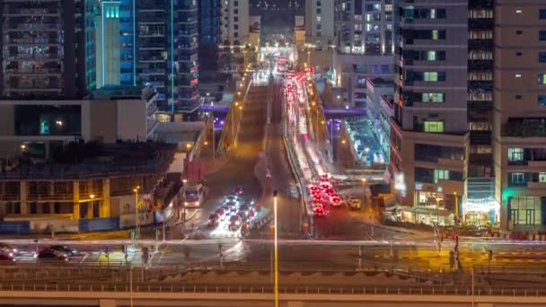 Aerial view with heavy traffic on a bridge and road intersection of JBR street night timelapse. — Stock Video