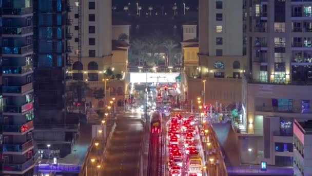 Aerial view with heavy traffic on a bridge and road intersection of JBR street night timelapse. — Stock Video