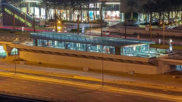 Bâtiment futuriste de la gare de tramway de Dubaï et du centre commercial derrière à Dubai Marina timelapse de nuit aérienne — Video