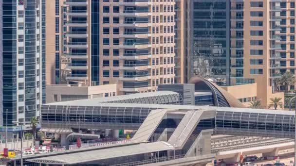 Futuristic building of Dubai tram station and luxury skyscrapers back in Dubai Marina air timelapse, United Arab Emirates — стокове відео