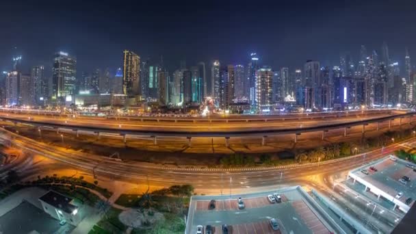 Panorama van Dubai Marina wolkenkrabbers en Sheikh Zayed weg met metro spoorlijn antenne nacht timelapse, Verenigde Arabische Emiraten — Stockvideo