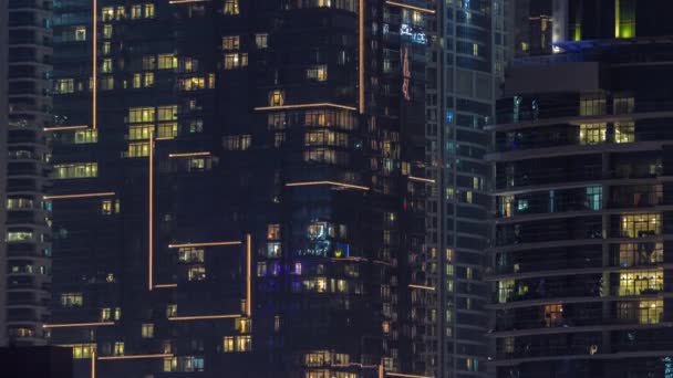 Widok nocy wielobarwnego światła w oknach wielopiętrowych budynków antenowy timelapse. — Wideo stockowe