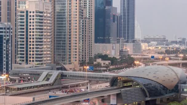Futuristická budova stanice metra Dubaj a luxusní mrakodrapy pozadu v dubajském přístavu letecký den na noc timelapse — Stock video