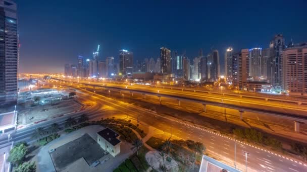 Dubai Marina arranha-céus e Sheikh Zayed estrada com metrô ferroviário noite a dia timelapse, Emirados Árabes Unidos — Vídeo de Stock
