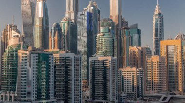 Gün batımında Dubai marinası gökdelenlerin en yüksek binası. JLT bölgesinden apartman binalarına, otellere ve otoyol yakınlarındaki iş kulelerine hava manzarası.