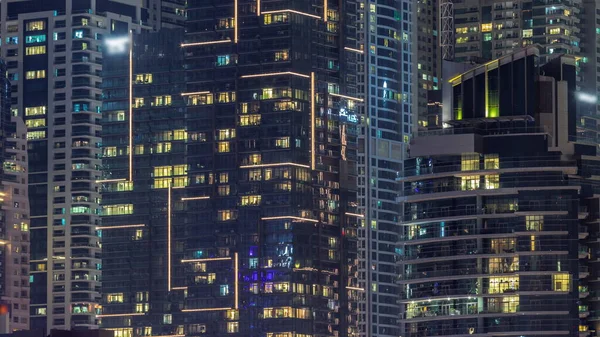 Çok katlı binaların panoramik pencerelerindeki gece görüşü hava zaman ayarlı. Büyük bir şehirde aydınlık bir gökdelen.