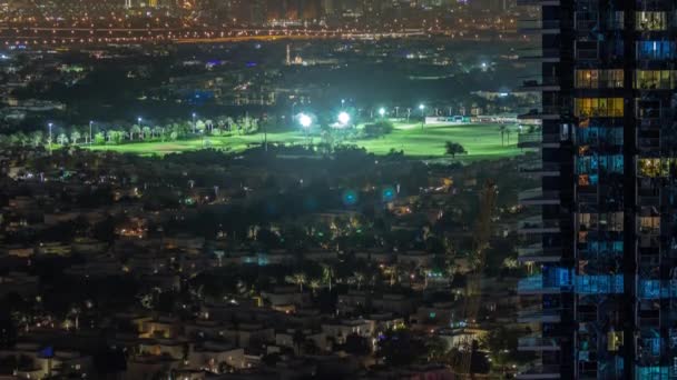 Vista aérea do passeio de desenvolvimento de habitação com arranha-céus do distrito JLT e lago artificial com uma timelapse noite parque. — Vídeo de Stock