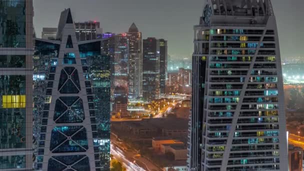 Edificios residenciales altos en el timelapse aéreo nocturno de JLT, parte del distrito de uso mixto del centro de productos básicos de Dubai. — Vídeos de Stock