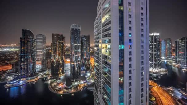 Edificios residenciales altos en el timelapse aéreo nocturno de JLT, parte del distrito de uso mixto del centro de productos básicos de Dubai. — Vídeos de Stock