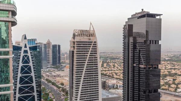 Edifícios residenciais altos no aeroporto JLT dia a noite timelapse, parte do Dubai multi-commodities center distrito de uso misto. — Fotografia de Stock