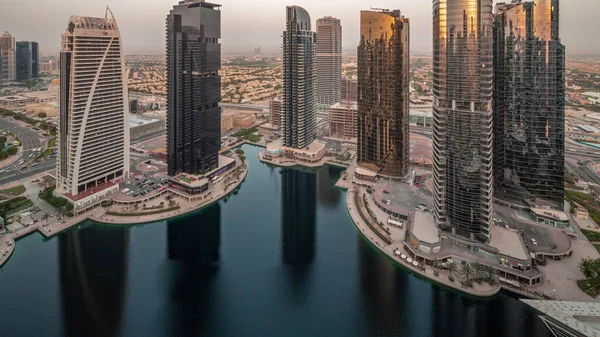 Edificios residenciales altos en la antena JLT día a noche timelapse, parte del distrito de uso mixto del centro de productos básicos de Dubai. —  Fotos de Stock