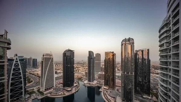 Edifícios residenciais altos no aeroporto JLT dia a noite timelapse, parte do Dubai multi-commodities center distrito de uso misto. — Fotografia de Stock