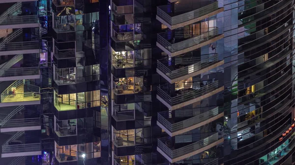 Apartman kulesindeki parlayan pencerelerin gece görüntüsü.