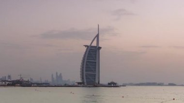 Dubai silueti Burj Al Arap oteli ile gündüz gece zaman çizelgesi.