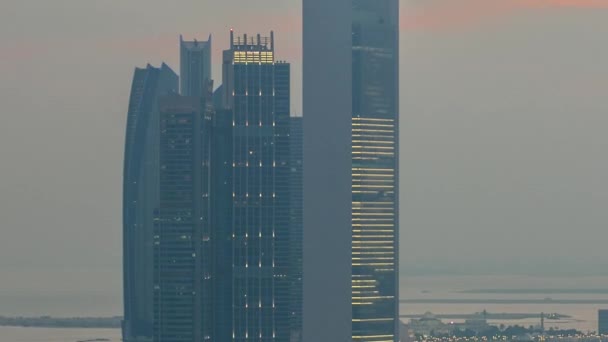 Vista superior de edificios famosos torres en Abu Dhabi día a noche timelapse. — Vídeos de Stock